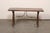 An Italian low-profile carved wood trestle-leg table, with forged-iron stretcher, from the 18th century. This antique...