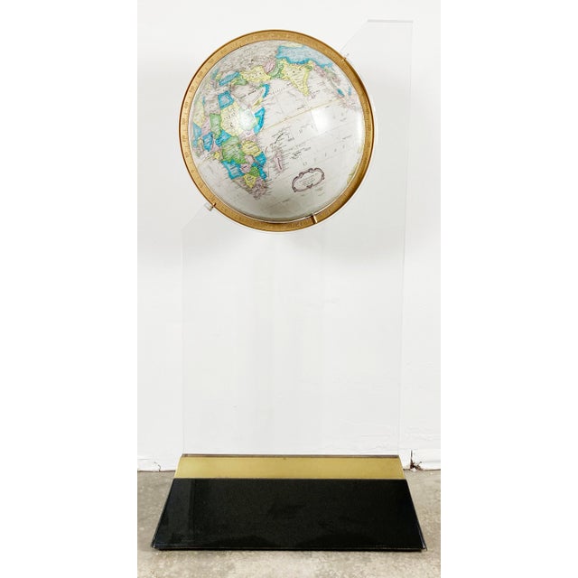 Vintage Postmodern style globe on acrylic and brass floor stand. Incredible presence with a chic presentation. Globe spins...