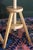 A pair of adjustable artist stools blonde wood with angular legs and exposed screw mechanisms. Each stool easily raises or...