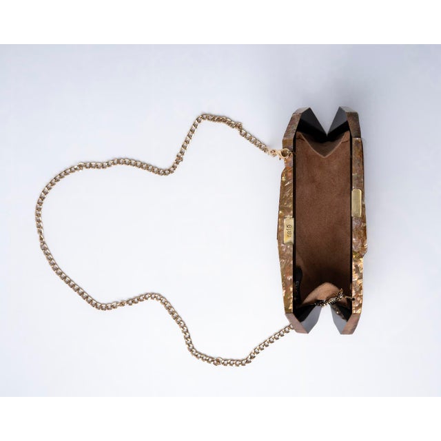 Inspired by modern architecture, the VIVIENNE Faceted Minaudière showcases bold angular planes, geometric precision, and a...