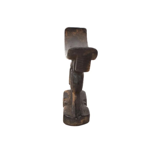 The Shona wood headrest was hand-carved by the Shona people of Zimbabwe. Headrests such as this were designed to support...