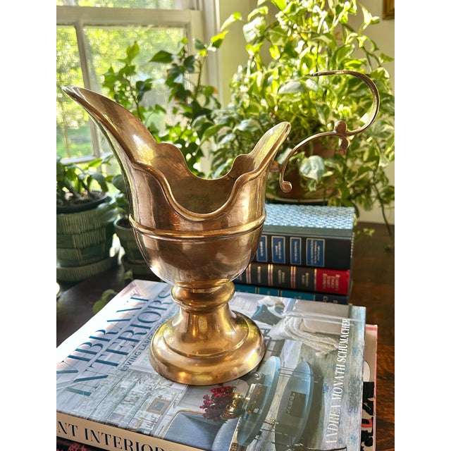 This is a brass pedestal ewer styled in the traditional manner of European lavabo vessels. The form is distinguished by a...