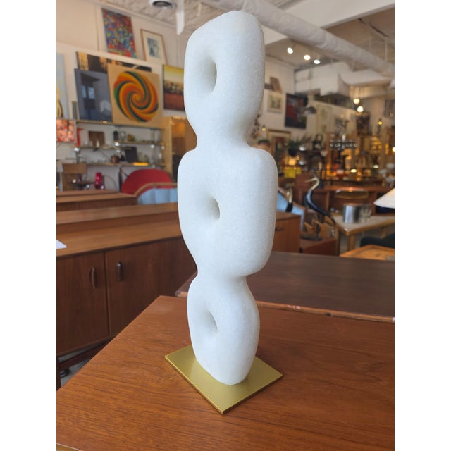 Elevate your space with this captivating biomorphic tabletop sculpture. Masterfully carved from white marble, the piece...