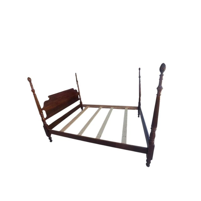 Elegant vintage Colonial Revival four poster rice bed featuring tall fluted posts, carved pineapple finials, and rich...