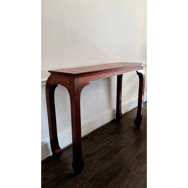 Elegant mahogany console table. A unique yet timeless design featuring curved chow legs, giving it a traditional, asian-...