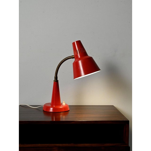 Scandinavian table lamp by Gemi in red lacquered metal, with a flexible, adjustable neck and perforated shade. Table lamp...