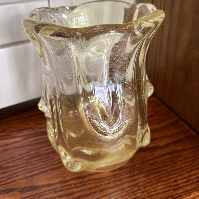 This Unique Shimmering Gold Flake Murano style Vase is a stunning piece of decorative glassware that exudes elegance and...