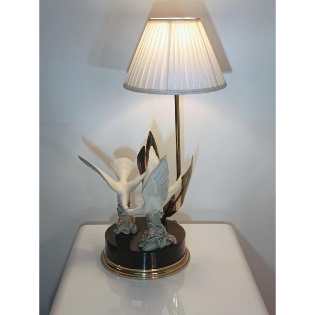 Magnificent vintage table lamp. Italy, 1980s. Brass frame. Black lacquered metal base with a brass band. Two resin doves...