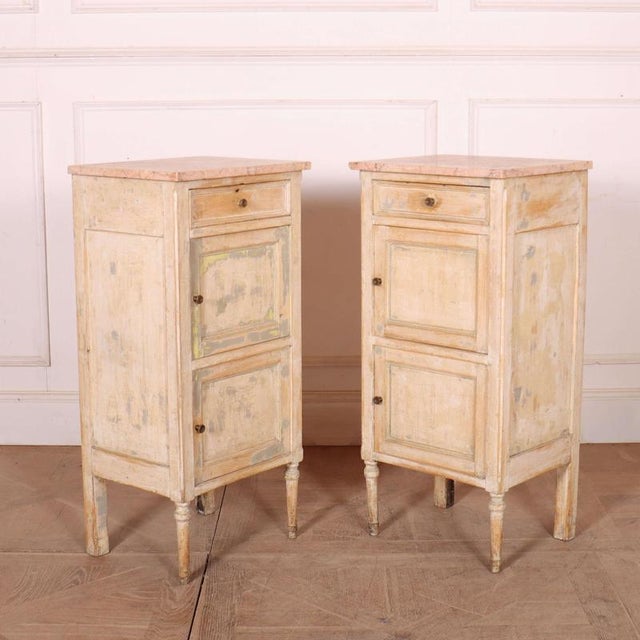 Interesting pair of 19th C French bedside cabinets with original paint and marble tops. 1850 This piece is designed in the...