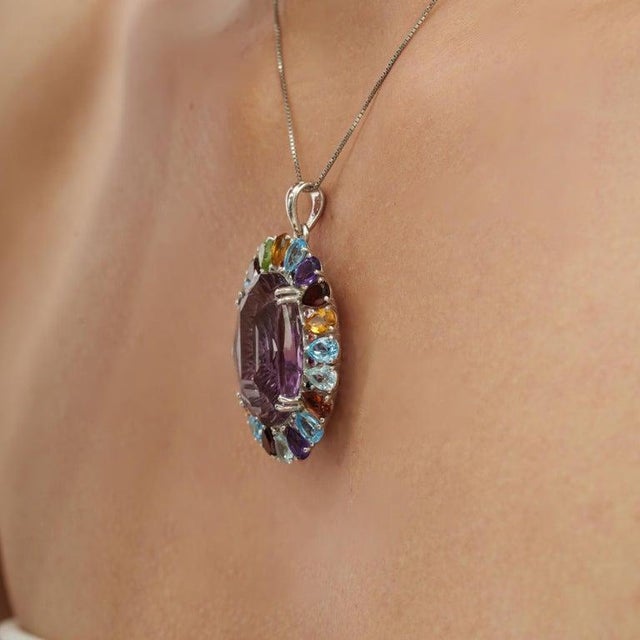 Crafted in 925 sterling silver, this Victorian-inspired halo pendant features 39.71 carats of trillion-cut natural multi...