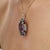 Crafted in 925 sterling silver, this Victorian-inspired halo pendant features 39.71 carats of trillion-cut natural multi...