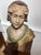 Polychrome plaster bust of a woman, depicting the abundance of the harvest, signed and numbered This piece has an...
