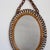 Italian oval-shaped rattan wall mirror (circa 1960s). This mirror has a very charming shape with rattan spirals framing...