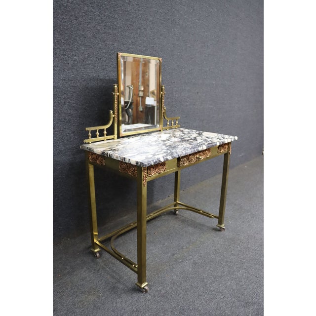 Elegant French Art Nouveau–style brass vanity table featuring a striking black-and-white breccia marble top and an...