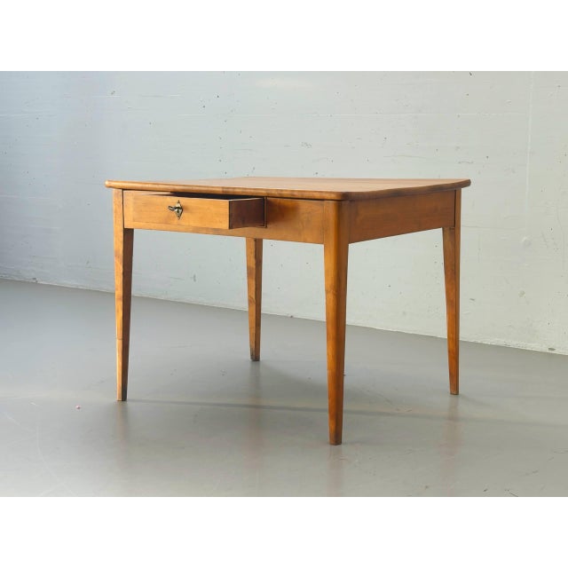 This biedermeier table impresses with its minimalist design and the warm, inviting tone of the solid cherry wood. The...