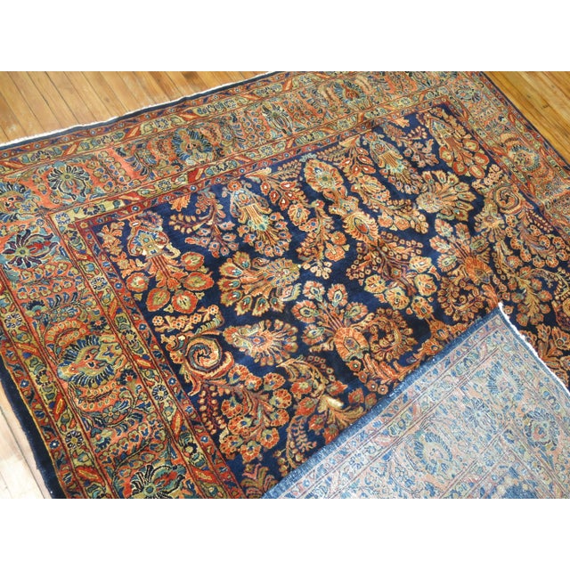 An elegant rare size early 20th century navy blue field antique Persian Sarouk. Salmon Pink undertones. Measures: 8'1" x...