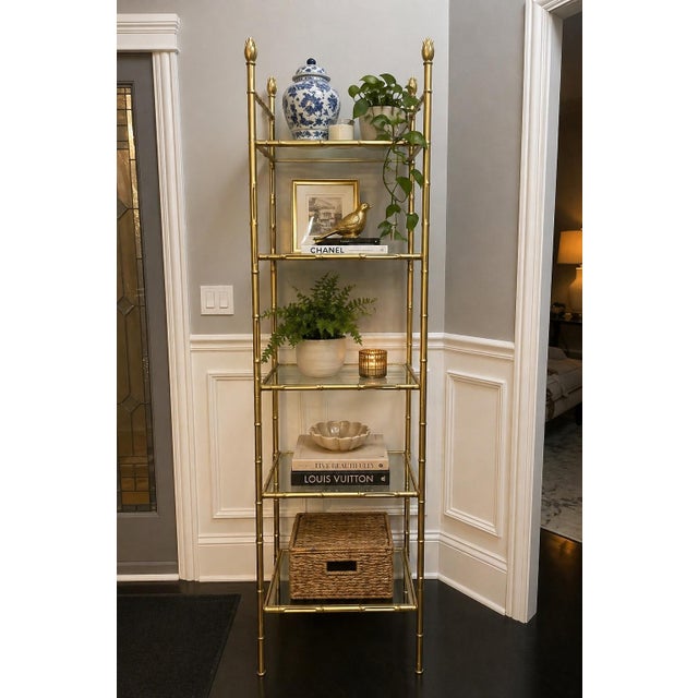Offered is a metal etagere with faux bamboo details and five removable glass shelves. This piece was recently painted...