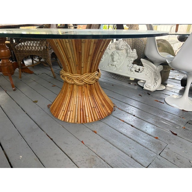 The McGuire 1960s Large Round Rattan Bamboo Dining Table with Glass Top is a stylish and unique piece of furniture for any...