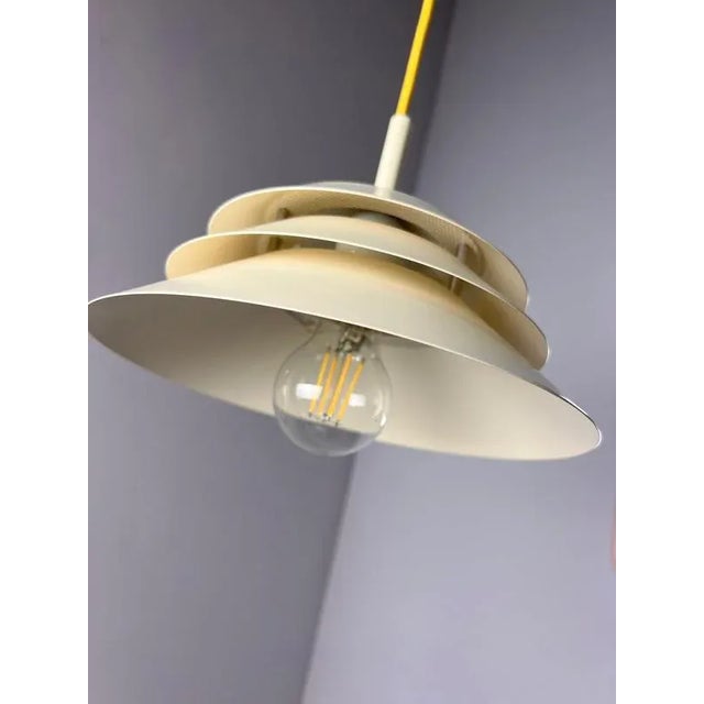 Soft light meets clear form: The Limino pendant lamp from Design Light impresses with its evenly layered, white slats,...