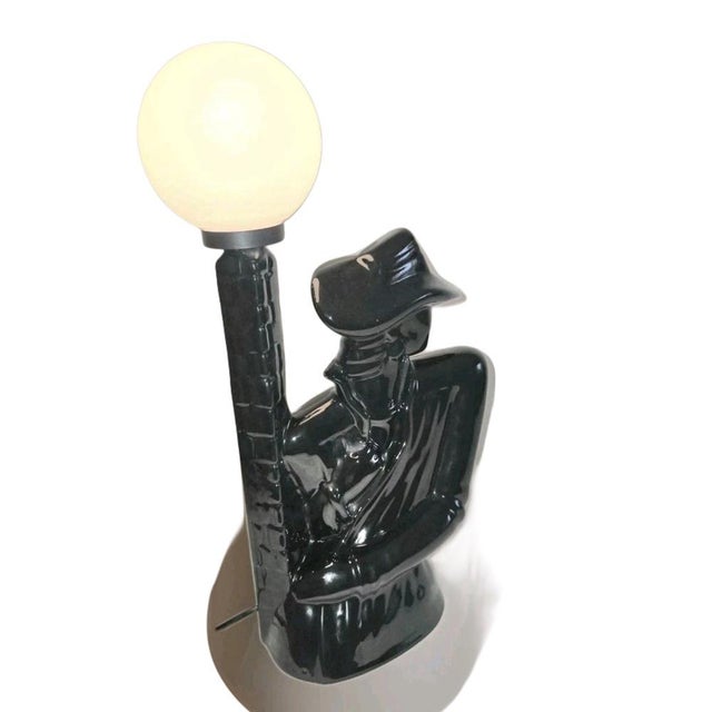 Table lamp from the 1980s with black glazed ceramic and a white glass globe shade. By Buthe Keramik It depicts a detective...