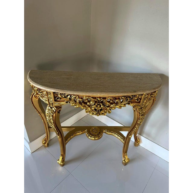 Elevate your interior with this exquisite French-style console table, featuring a light beige marble top and a fully...