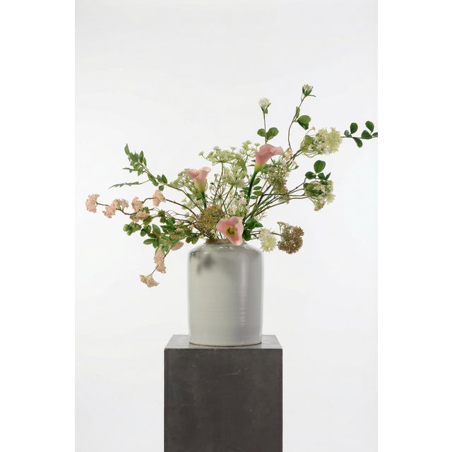 An expressive composition built around blush calla lilies, Queen Anne’s lace, and soft green branching stems. The palette...
