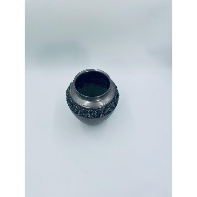 Vintage decorative vase, crafted from plated metal. The vase features a classic urn shape, a textured body with visible...