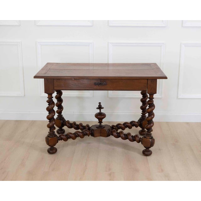 Produced in France during the nineteenth century, this walnut table is worked in the Louis XIII style, a revival of the...