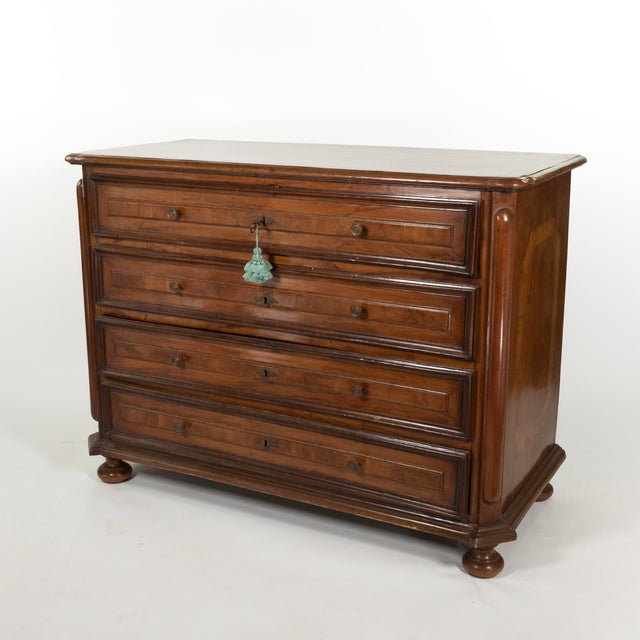 An early 18th-century Italian walnut commode, its top with a moulded edge and rounded corners, over four large drawers...