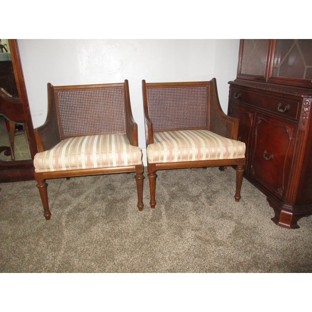 This is a Beautiful Pair of 1940s Regency Style Cane Back Walnut Bergere Chairs that are all Original finish that have...