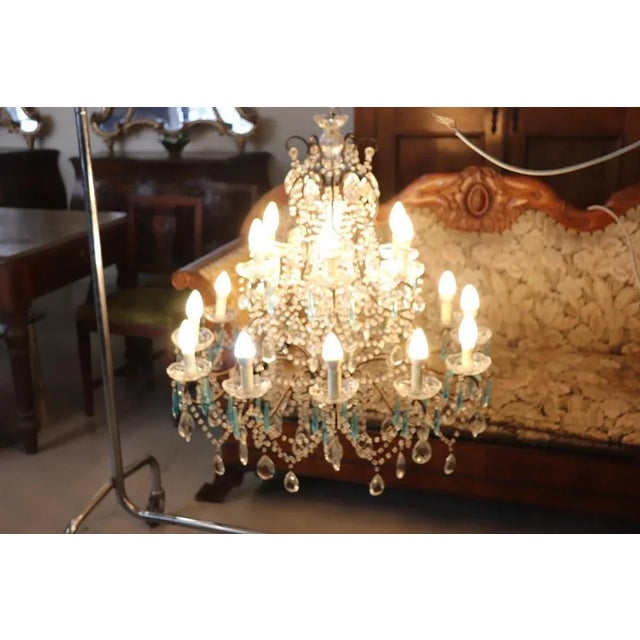 Beautiful and refined Italian 1930s chandelier with 18 bulbs. The lights are arranged on two floors. In patinated bronze...