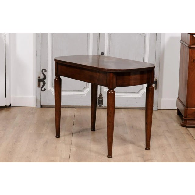 An Italian walnut side table from circa 1890 with oval top, single drawer and cylindrical tapering legs. This Italian...