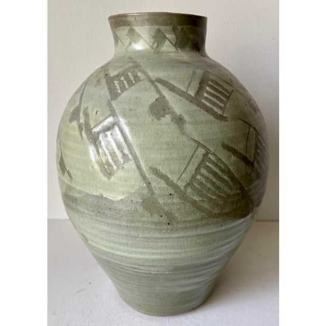 This gorgeous and rare vintage Chinese celadon vase features abstract incised designs and is mounted on a hand-carved...