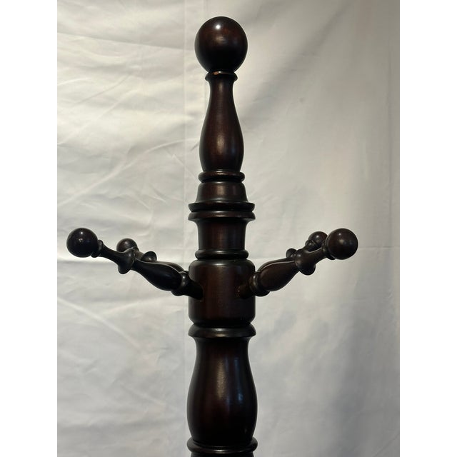 Hall tree, hat and coat rack. Mahogany wood. Eight hooks. Ball ends. Early 20th century. 72" height.