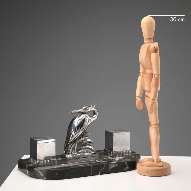 Art Deco inkwell with bird and metal cruet holder on a black marble base. Glass cruets. This piece is attributed to the...