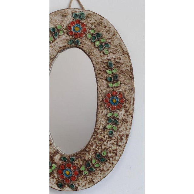 Ceramic flower-motif wall mirror with glazed leaves attributed to la roue, vallauris, france (circa 1960s). A charming,...