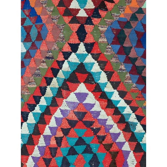 This Mid-20th century Persian flatweave kilim presents a dramatic, kaleidoscopic composition built around two large,...