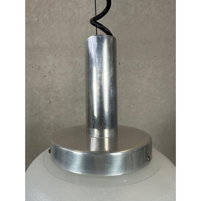 Vintage pendant lamp. Glass globe. Aluminium fixture. Long coiled cable. Equipped with a steel cable to secure the...