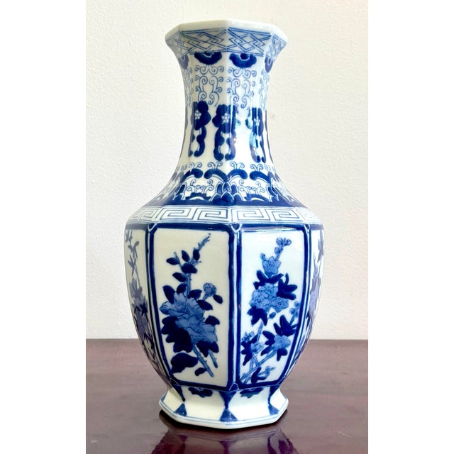 This hexagonal blue-and-white porcelain vase exudes classic elegance, with hand-painted panels of florals bordered by...