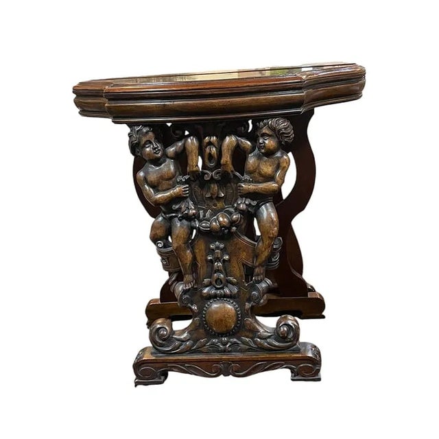 Ornately carved cherub console tables featuring putti and intricate fruit motifs on richly finished wood. Measurements are...