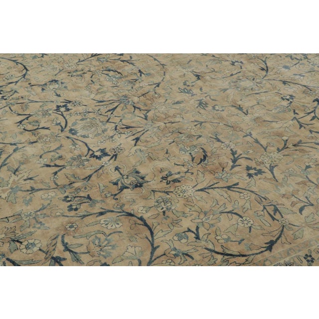 Hand-knotted in wool, this 11x13 antique Kerman rug, circa 1900-1920, is a refined example of Persian weaving celebrated...