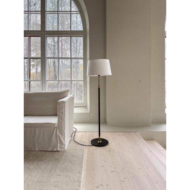 This floor lamp in brass and black metal, designed by aage petersen for le klint. Denmark, 1970s. A modern look floor lamp...