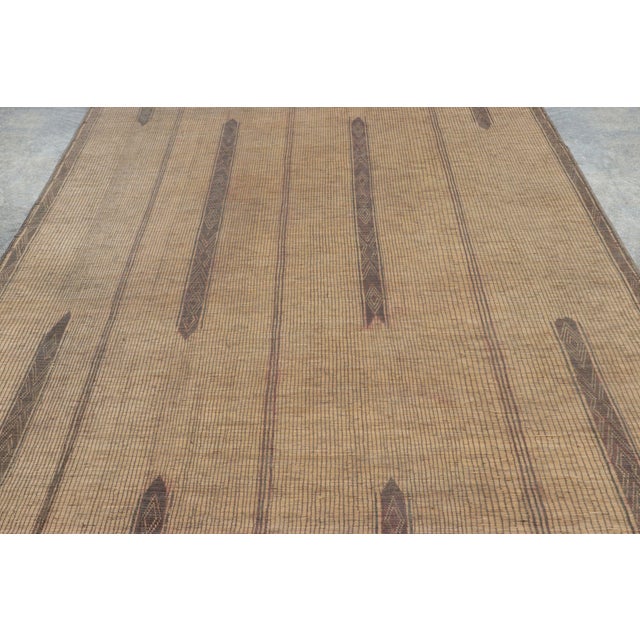 Made with handwoven reed and camel leather in Mauritania circa 1950-1960, this 7x16 vintage Tuareg runner mat is an...