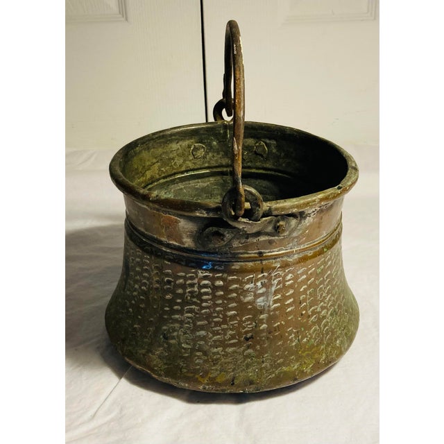Antique copper & iron bucket for water with elaborate cartouches etched around sides bulbous shaped bottom tapering up...