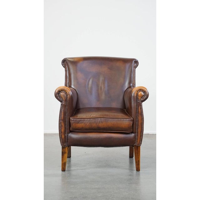 Dark brown cowhide English style armchair/armchair with a robust appearance. This fantastic cowhide leather armchair has a...