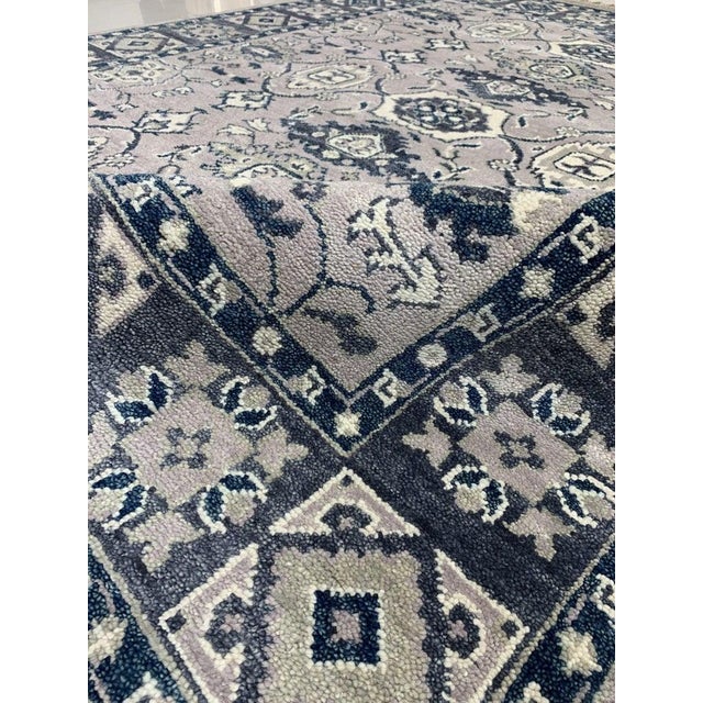 This gray wool rug features a hand knotted pile construction and originates from India. It is a classic traditional rug...