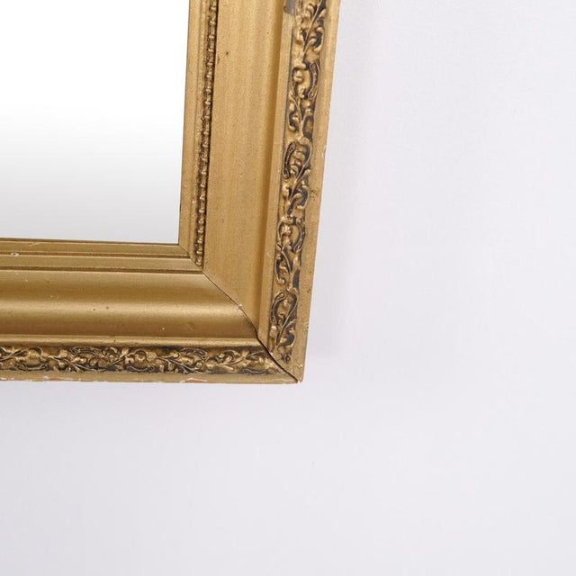 Antique mirror with a gilded frame dating from the 1890s. The mirror features a classic appearance with decorative details...