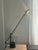 This is a 1990s post modern desk lamp featuring a sleek matte black finish. It can be adjusted for flexible lighting and...