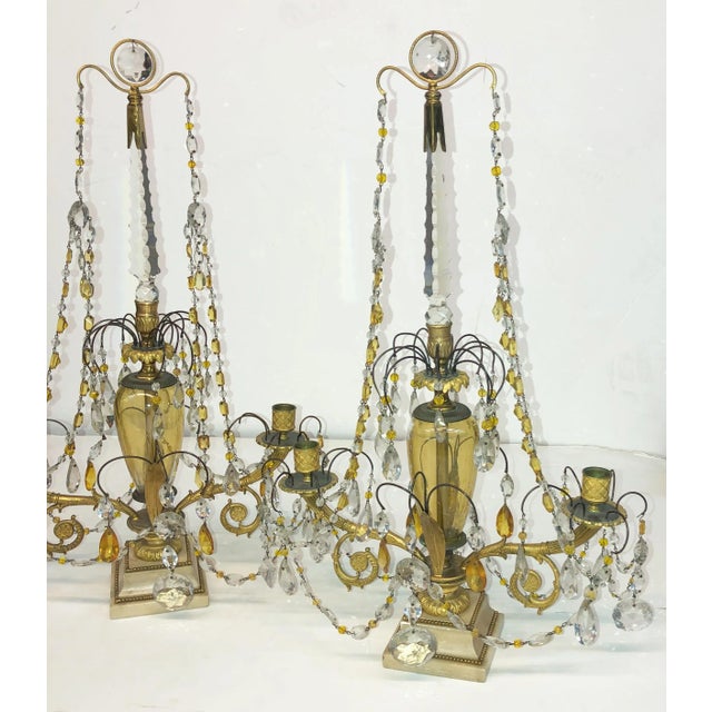 A fine and rare pair of Russian Neo Classic candelabra, with cut crystal facets and drops, cut amber-colored glass, a...