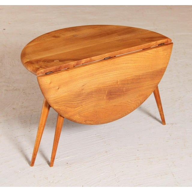 Mid Century Ercol elm and beech drop-leaf side table, circa 1960s. Excellent restored condition. H: 40.5cm W: 61cm D: 61cm...